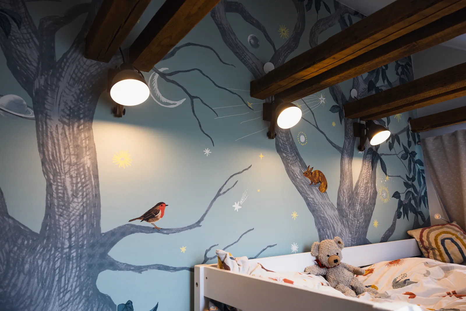 Kinderzimmer mit gemaltem Waldmotiv über die gesamte Wand und Hochbett aus Holz